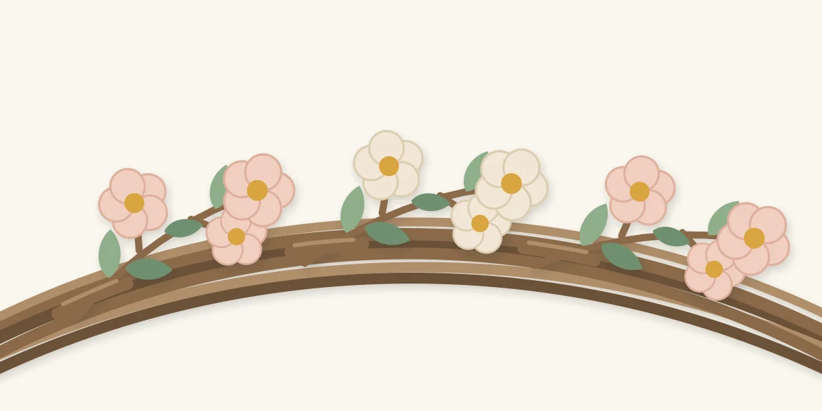 Three short blossom twigs tucked into grapevine at a shallow angle with vine showing between